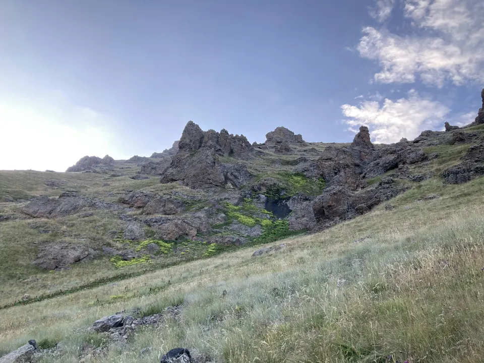 Grassy slopes and rocky crags on Mount Aragats