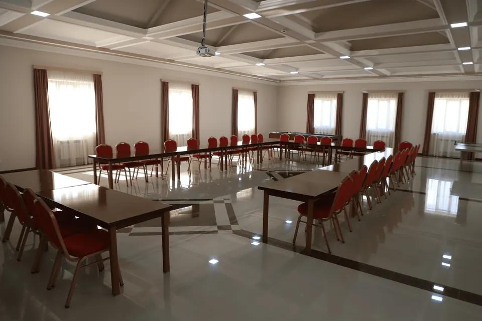 Conference hall set with long tables and red chairs
