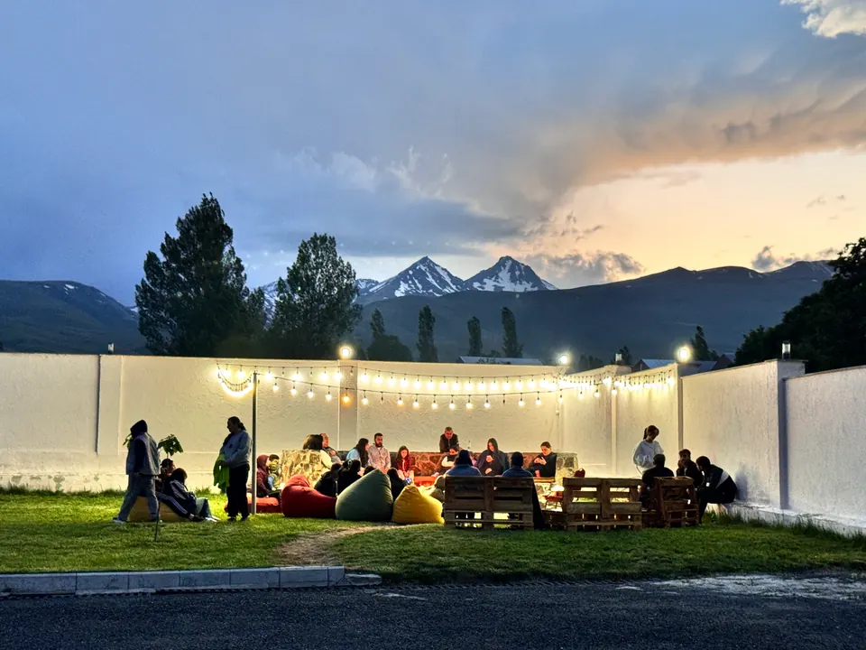 The hotel courtyard at dusk with string lights and Mount Aragats behind