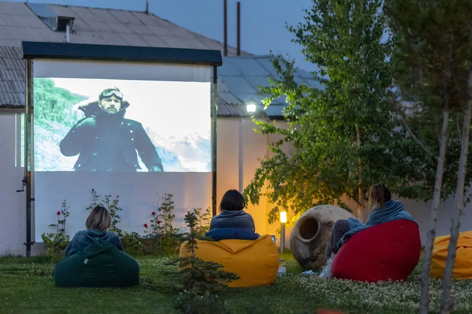 Guests on bean bags watching an open-air film in the garden