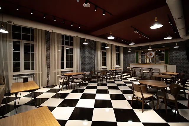 The hotel restaurant with checkerboard floor and wooden tables